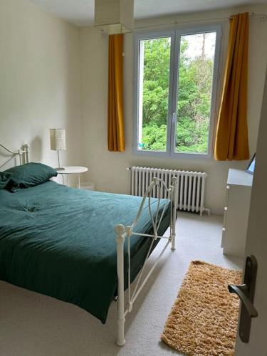 une chambre avec un lit et une grande fenêtre dans l'établissement repos en forêt, à Huelgoat