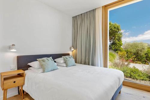 une chambre avec un grand lit et une grande fenêtre dans l'établissement Villa A Grana, à Zonza