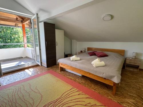 ein Schlafzimmer mit einem Bett und einem großen Fenster in der Unterkunft Hotri House On The River Island in Ripač