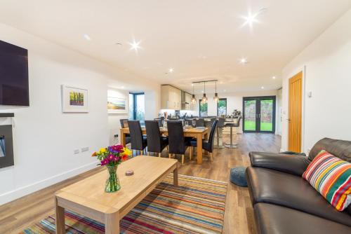 a living room with a couch and a table at Gardd Y Llys Luxurious Family Retreat with amazing views in Llandrillo-yn-Rhôs