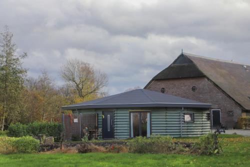 a green building with a black roof next to a barn at Silo 161 in Ruinerwold