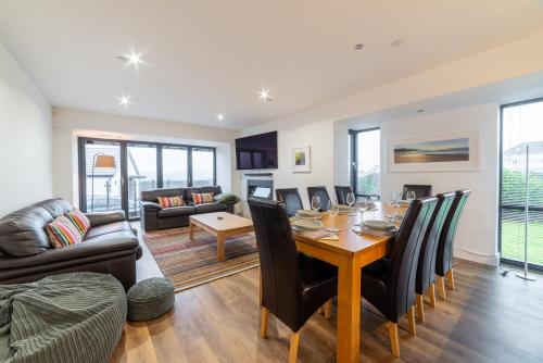 a living room with a table and chairs and a couch at Gardd Y Llys Luxurious Family Retreat with amazing views in Llandrillo-yn-Rhôs