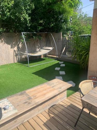 une arrière-cour avec une terrasse en bois et une balançoire dans l'établissement La baie d’Alon, à Saint-Cyr-sur-Mer