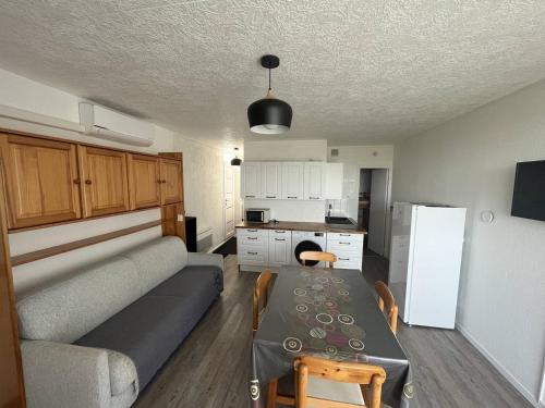 un salon avec un canapé et une table et une cuisine dans l'établissement Studio Moderne - Proche Plage - Parking - FR-1-324A-47, à Saint-Hilaire-de-Riez