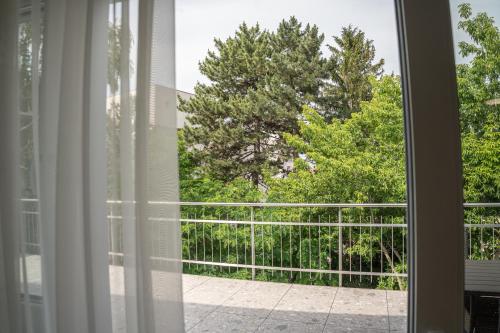 an open window with a view of a tree at DIAMOND Luxury Apartments in Siófok