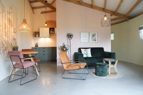 a living room with a couch and chairs and a table at Silo 161 in Ruinerwold