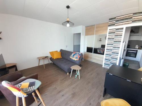 un salon avec un canapé, une table et des chaises dans l'établissement Appartement T2 rénové, à 2 pas de la plage avec parking, Wifi et animaux admis ! - FR-1-324A-55, à Saint-Hilaire-de-Riez