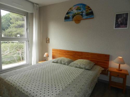 une chambre avec un grand lit et une fenêtre dans l'établissement Appartement T2 proche plage et commerces, 4 couchages, Bormes-les-Mimosas - FR-1-251-765, à Bormes-les-Mimosas