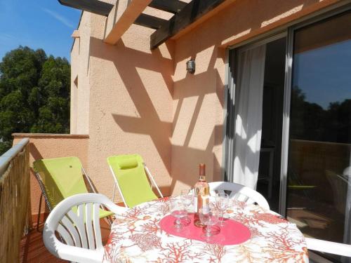 une table et des chaises sur le balcon d'une maison dans l'établissement Appartement Confort 2 P. avec Terrasse, Plage et Commerces à 200 m - Parking Privé Inclus - FR-1-251-715, à Bormes-les-Mimosas