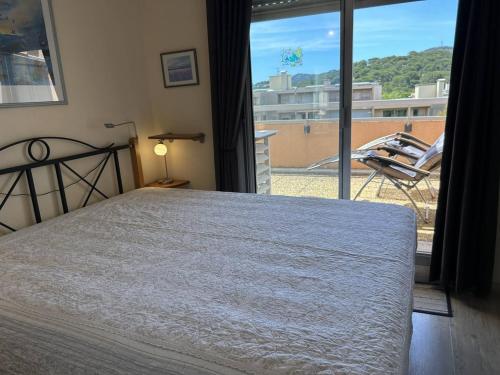 une chambre avec un lit et une vue sur un balcon dans l'établissement Duplex climatisé avec 2 terrasses, garage, à 200m de la plage et proche commerces - Bormes-les-Mimosas - FR-1-251-733, à Bormes-les-Mimosas