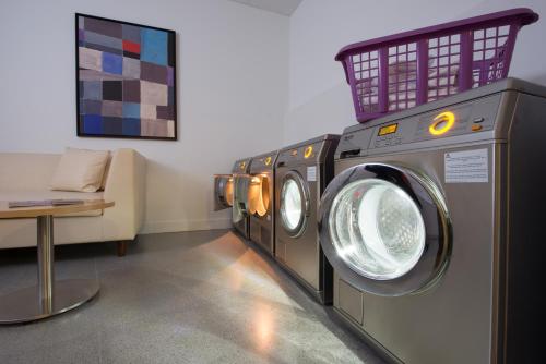 a row of washing machines in a laundry room at Capri by Fraser Barcelona in Barcelona