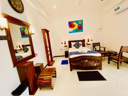 a bedroom with a bed and a mirror at Airport Faith Hotel in Katunayake