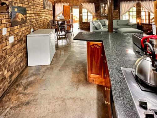 a kitchen with a counter and a living room at Zaganaga Kruger Lodge in Marloth Park
