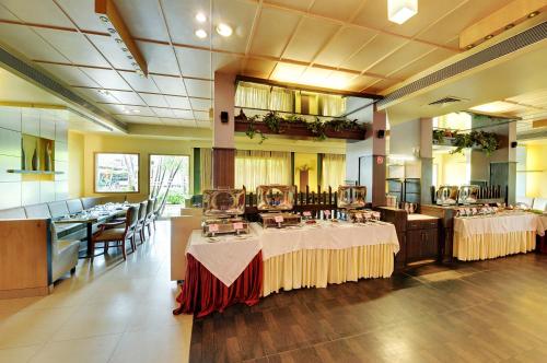 un restaurante con 2 mesas con mantel blanco en Hotel Sankam Residency en Belgaum