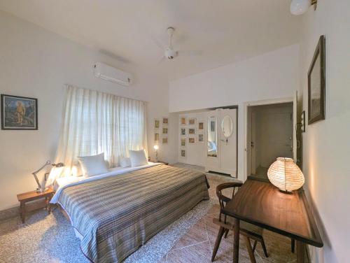 a bedroom with a large bed and a wooden table at Fouzdar House by LuxUnlock Private Villas in Ahmedabad