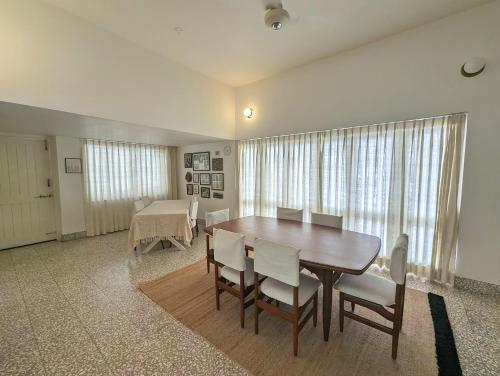 a dining room with a wooden table and chairs at Fouzdar House by LuxUnlock Private Villas in Ahmedabad