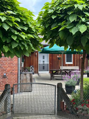 a fence in front of a yard with a patio at Ferienhaus Fichtenschloss in Salzhausen