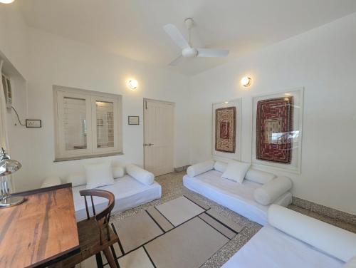 a living room with two white couches and a table at Fouzdar House by LuxUnlock Private Villas in Ahmedabad