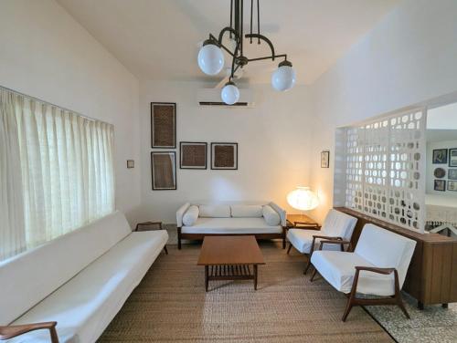 a living room with a couch and a table at Fouzdar House by LuxUnlock Private Villas in Ahmedabad