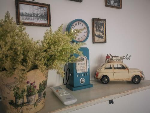 a toy car sitting on a shelf next to a clock at Kúria Apartman Budapest with free parking in Budapest