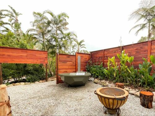 a garden with a bath tub and a wooden fence at Adventurer's Escape HQ in Harkerville