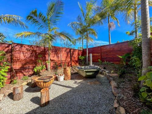 a garden with a bath tub and palm trees at Adventurer's Escape HQ in Harkerville