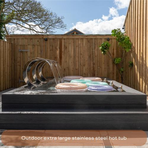 a fountain with plates on a table in front of a fence at The Mini Stylish Getaway in Corsley