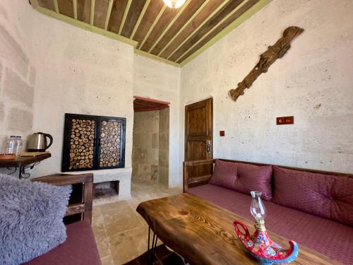 a living room with a purple couch and a table at Almula Cave in Avanos