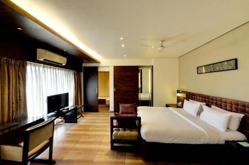 a hotel room with a bed and a television at Hotel Sankam Residency in Belgaum