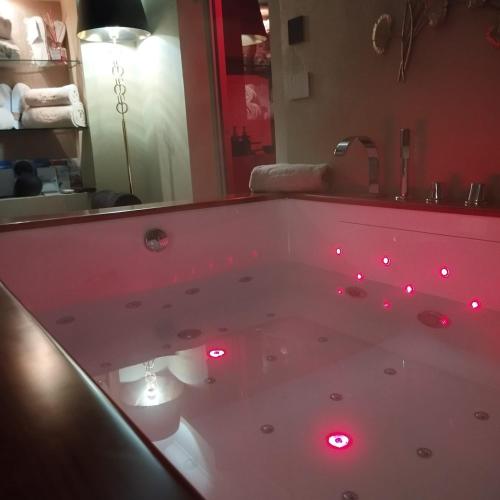 a bath tub with red lights in a bathroom at Siramà Suite Deluxe in Oria