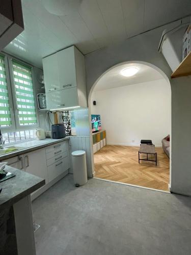 une cuisine avec une arche menant à un salon dans l'établissement Petit cocon parisien ! Paris Centre - Gare du Nord, à Paris