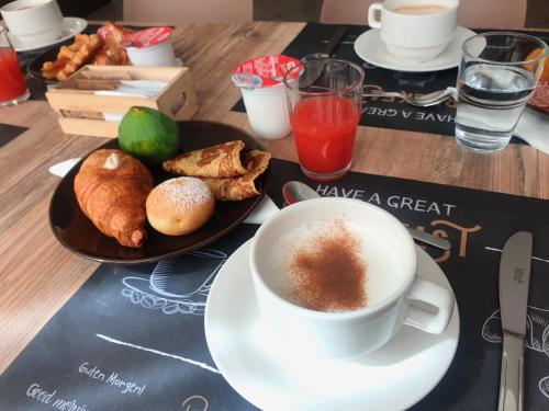 a table with a cup of coffee and a plate of pastries at Hotel Bianca Vela in Rimini