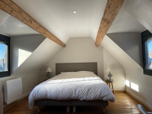 um quarto com uma cama branca e 2 janelas em Villa Madeleine rénovée plage hyper centre em Trouville-sur-Mer