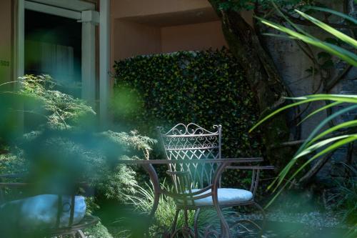 a bench sitting next to a table in a garden at Seven Boutique Hotel in Ascona