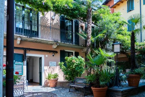 a building with plants and a bench in front of it at Seven Boutique Hotel in Ascona
