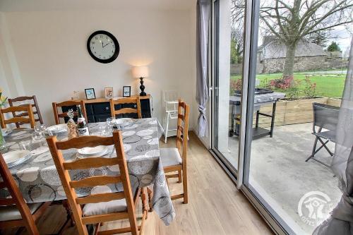une salle à manger avec une table et une horloge au mur dans l'établissement Ty linalae, à Pordic