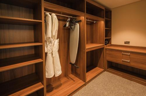 a walk in closet with wooden shelves and cabinets at Dunadry Hotel And Gardens in Antrim