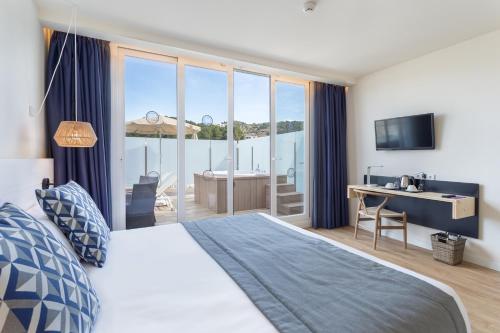 ポルト・デ・ソリェルにあるFERGUS Style Soller Beachのベッドとデスクが備わる眺めの良い客室です。