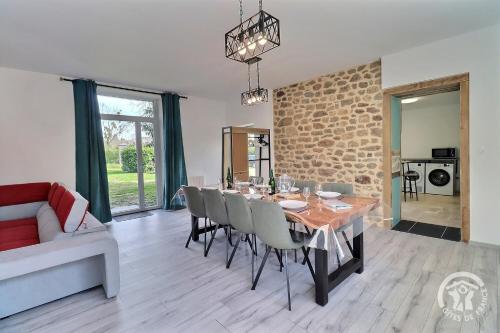 une salle à manger avec une table, des chaises et un canapé dans l'établissement Des alleux, à Saint-Ouen-des-Alleux