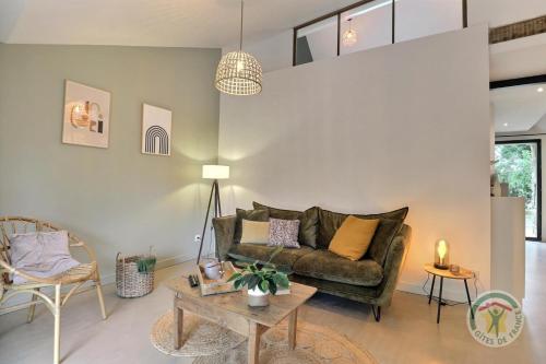 a living room with a couch and a table at Victor in Saint-Georges-de-Chesné