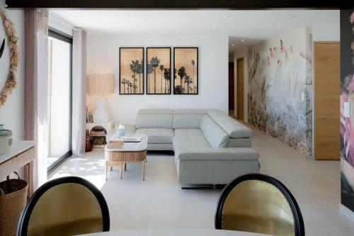 a living room with a couch and a table at La Perle Rose Villa Standing 5 étoiles avec piscine jacuzzi et superbe vue in Aigues-Mortes