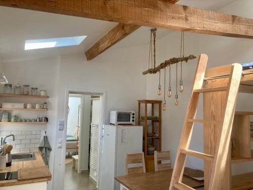 a kitchen with a ladder and a refrigerator at Sous deux chênes in Vieux-Boucau-les-Bains