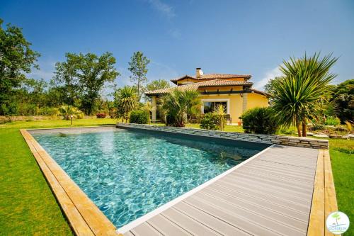 une piscine devant une maison dans l'établissement Villa avec Piscine Parentis en Born 13 personnes, à Parentis-en-Born