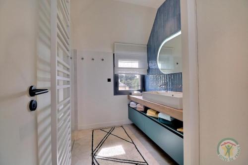 une salle de bain avec un lavabo et un miroir dans l'établissement Les dunes, à Saint-Lunaire
