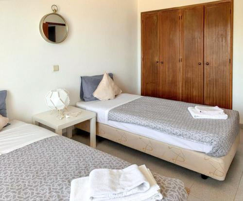 - une chambre avec 2 lits et un miroir dans l'établissement 2 bedrooms apartement at Carvoeiro 100 m away from the beach with sea view balcony and wifi, à Carvoeiro