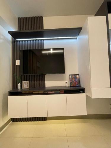 a living room with a tv on a wall at Studio 7 in Manila