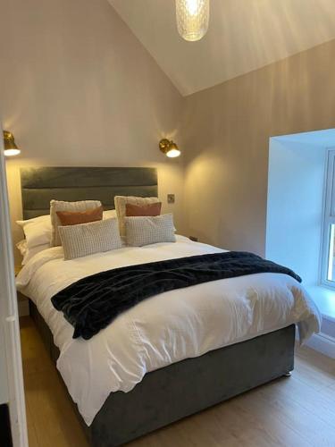 a bedroom with a large bed with white sheets and pillows at An Riasc Farmhouse Rental in Dingle