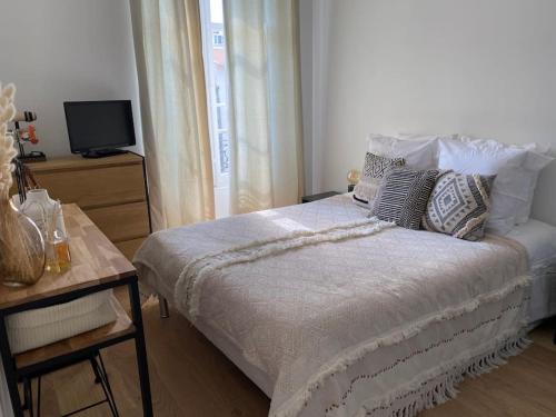 - une chambre avec un lit doté d'oreillers et une télévision dans l'établissement Cannes banane, T2 centre ville, 400 m des plages, à Cannes
