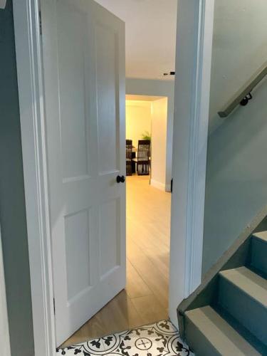 a white door leading to a hallway with stairs at An Riasc Farmhouse Rental in Dingle