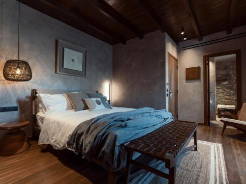 a bedroom with a bed and a bench in it at KaSeas Boutique Hotel in Gerolimenas